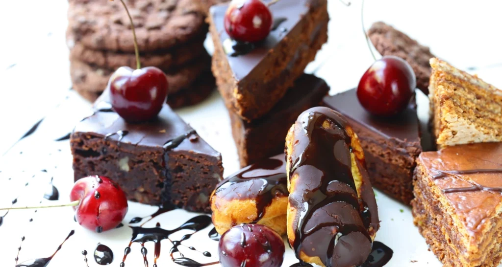 A rich, moist slice of chocolate cake topped with smooth chocolate ganache and fresh raspberries.